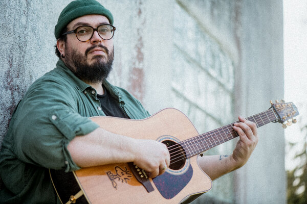 Bild vergr&ouml;&szlig;ern: Portrait des Musikers Mathias Kellner mit seiner Gitarre.