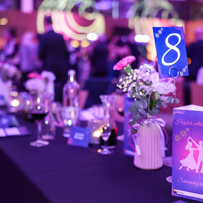 Detailaufnahme der Tischdeko beim Schwandorfer Stadtball. Die dominierenden Farben sind schwarz, pink und lila.
