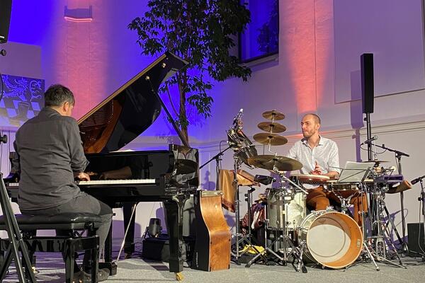 Pianist Chris Gall am Piano. Percussionist Bernhard Schimpelsberger am Schlagzeug auf einer stimmungsvoll beleuchteten Bhne.