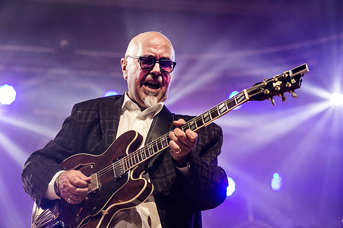 Foto von Todor Todorovic. Der Bandleader der Blues Company spielt Gitarre. Der Hintergrund ist lilafarben.