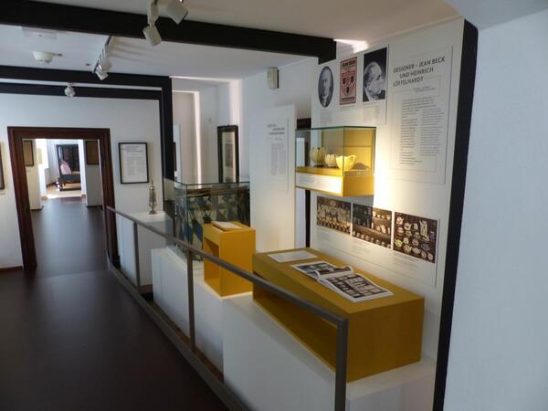 Foto eines Ausstellungsraumes: Es sind Produkte der historischen Tonwarenfabrik aus Schwandorf und einer Trommel, die mit Informationstexten dargestellt werden.