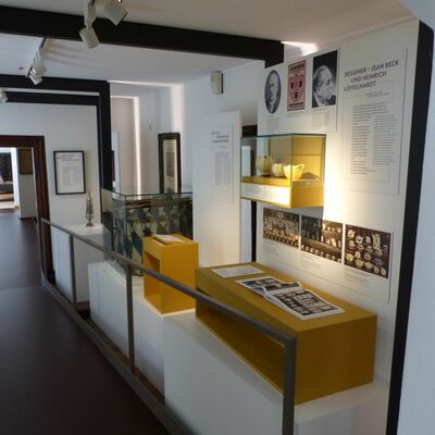 Foto eines Ausstellungsraumes: Es sind Produkte der historischen Tonwarenfabrik aus Schwandorf und einer Trommel, die mit Informationstexten dargestellt werden.