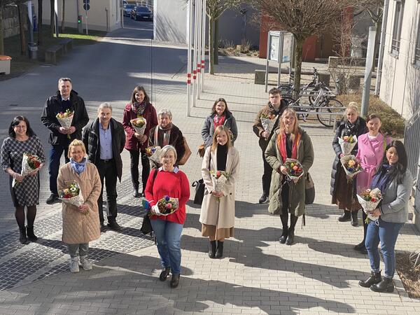 Bild vergrößern: 14 Personen erhalten einen  Blumenstrauß.