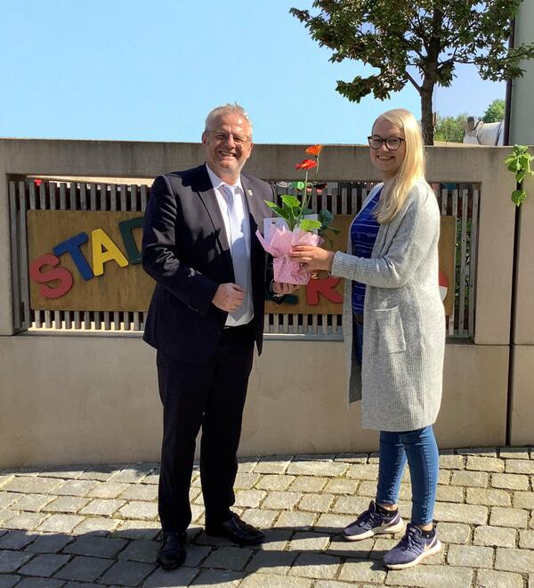 Bild vergrößern: Ein Mann überreicht einer Frau einen Blumenstrauß.