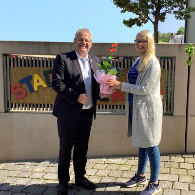 Ein Mann &uuml;berreicht einer Frau einen Blumenstrau&szlig;.