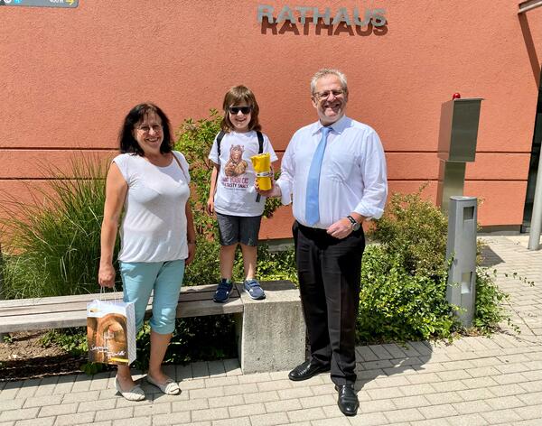 Eine Frau, ein Kind und ein Mann vor dem Rathaus Schwandorf.